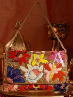 Colorful beaded handbag with floral designs on a decorative background