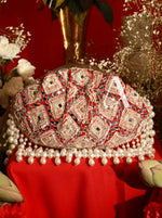 Decorative clutch bag with intricate design on a red background