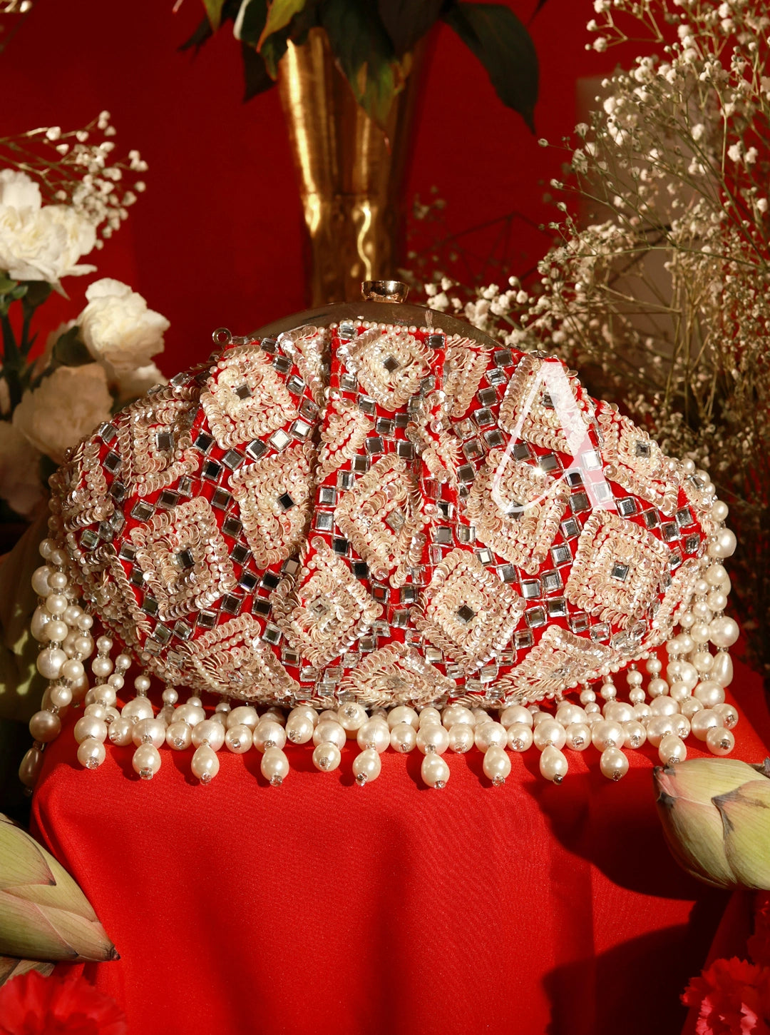 Decorative clutch bag with intricate design on a red background