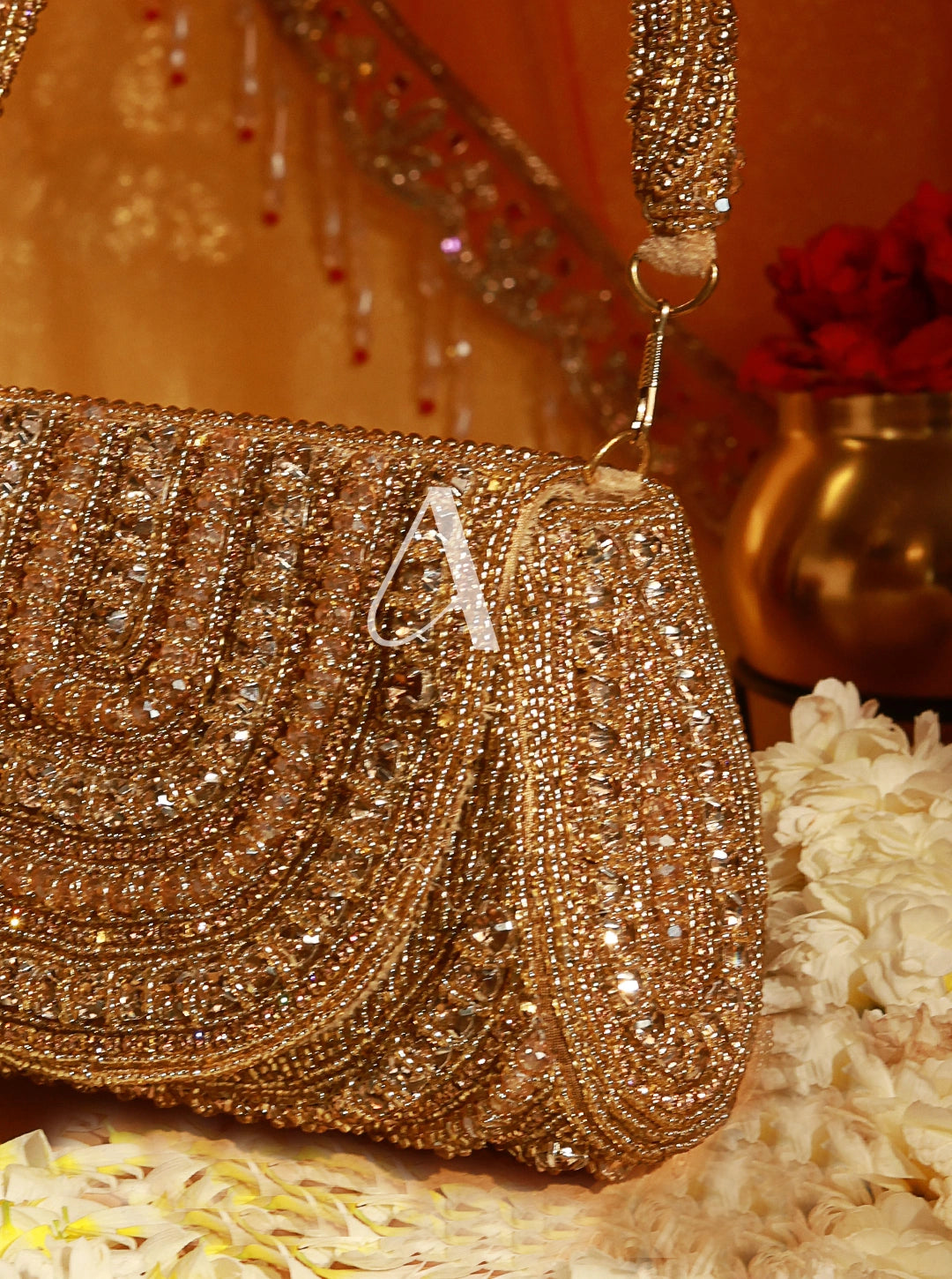 Gold beaded clutch with a letter 'A' on a decorative background
