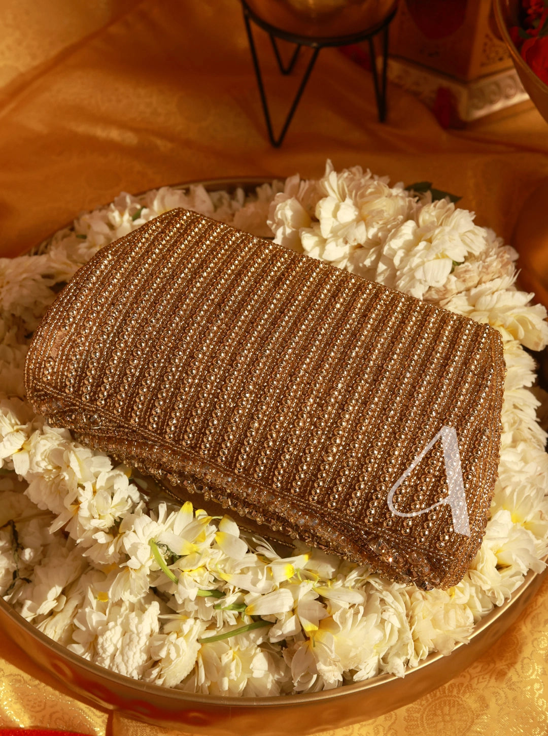 Brown textured box with a white letter 'A' on a bed of white flowers.