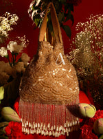 Gold beaded handbag with fringe on a red background with flowers