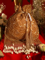 Gold beaded handbag with tassels on a red background