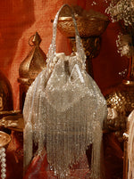Silver beaded handbag with fringe on a decorative background