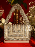 Decorative handbag with crystals on a red surface with flowers in the background