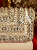 Close-up of a sparkling clutch with 'A' initials on a blurred background
