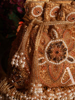Decorative item with gold embroidery and pearls on a dark background
