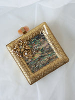 Decorative gold box with intricate designs on a white background