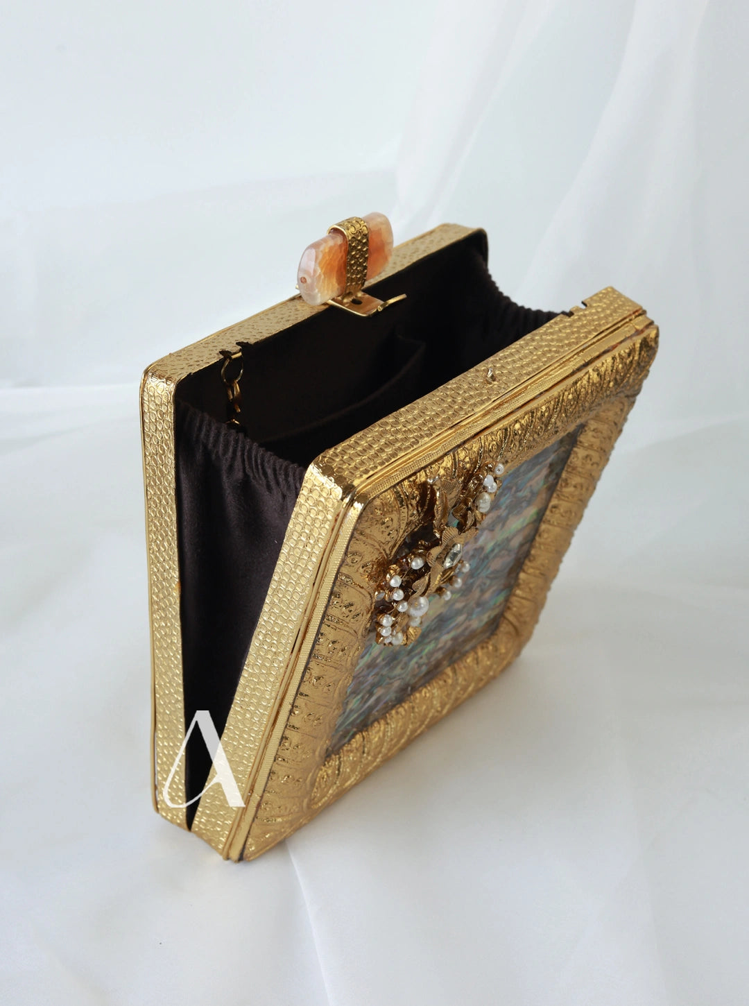 Gold clutch bag with decorative elements on a white background
