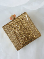 Gold embossed clutch bag on a white background