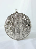 Decorative silver clutch with intricate patterns on a white background