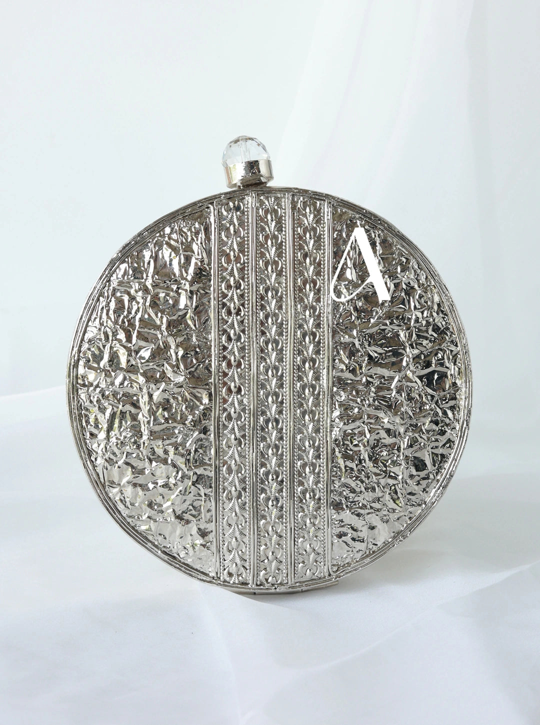 Decorative silver clutch with intricate patterns on a white background