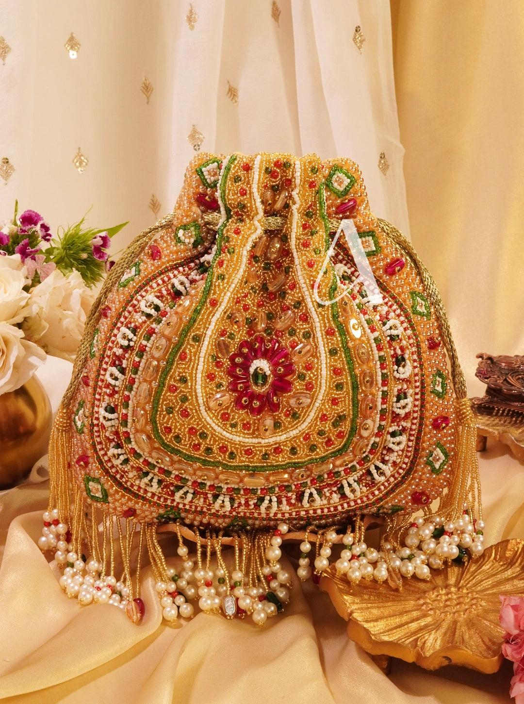 Decorative handbag with intricate patterns and pearl embellishments on a decorative background.