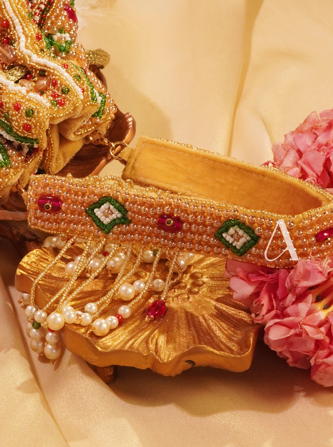 Gold bracelet with decorative elements on a floral background