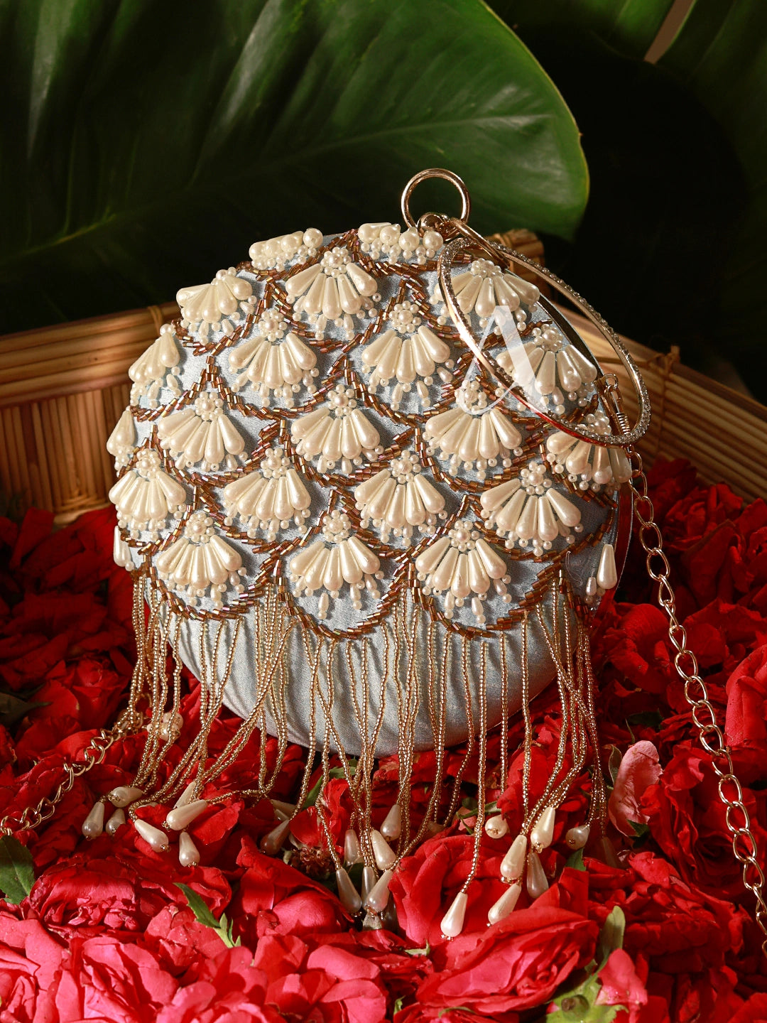 Decorative handbag with shell-like patterns on a red floral background