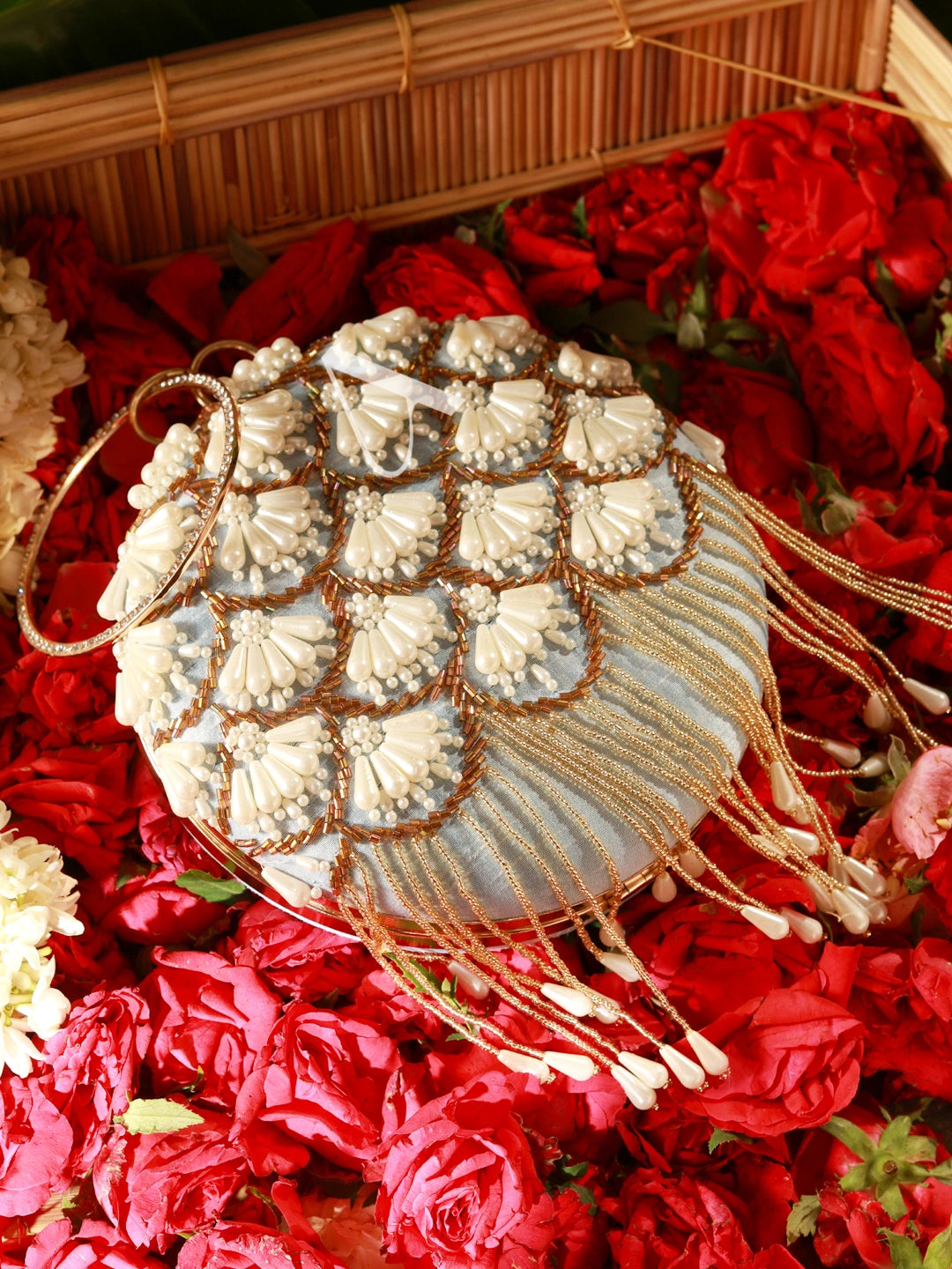 Decorative handbag with floral patterns on a bed of red flowers