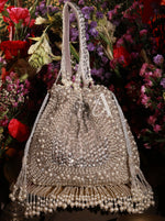 Beaded handbag with fringes against a floral background
