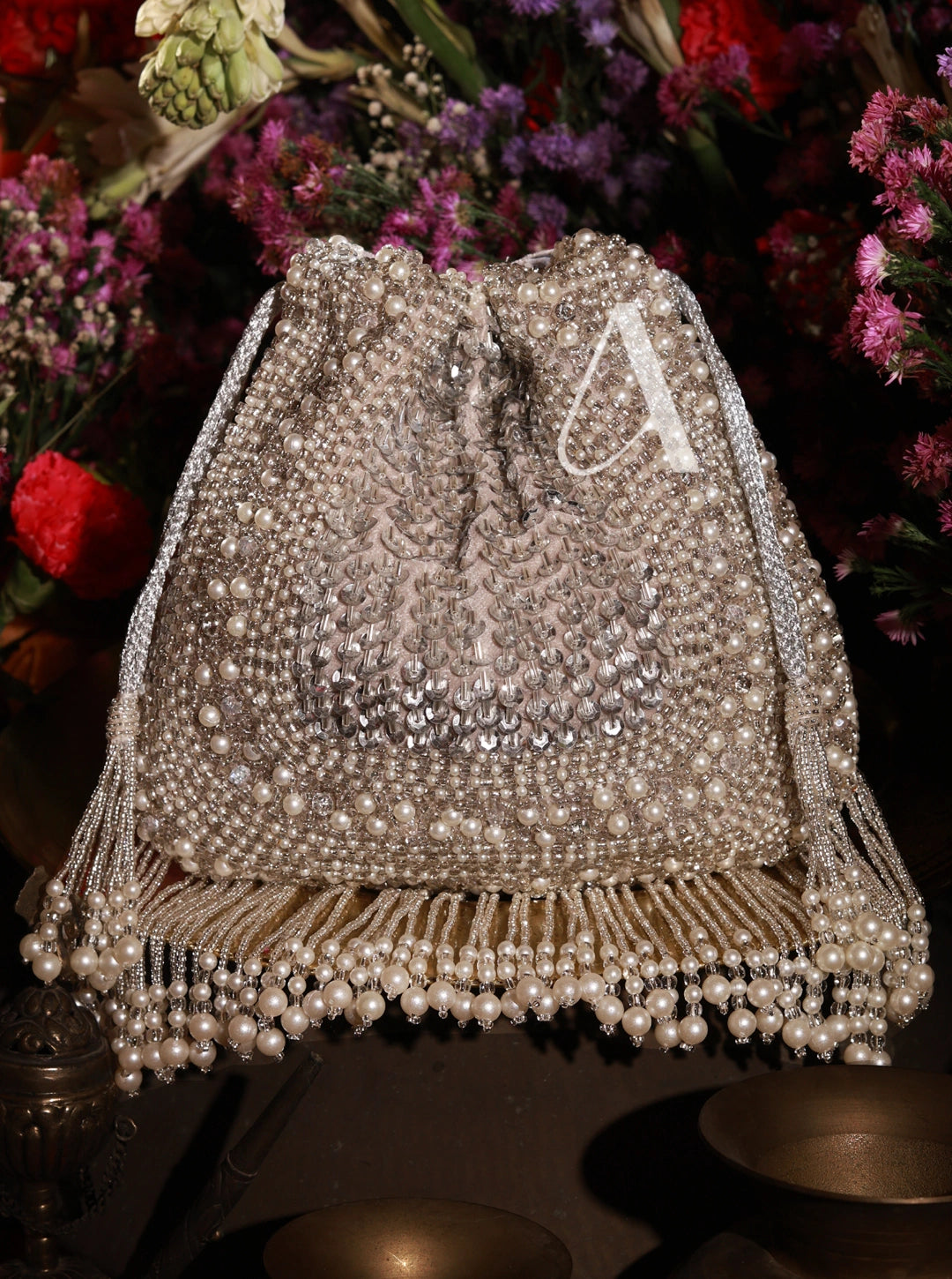 Decorative lampshade with pearls and a letter 'A' against a floral background