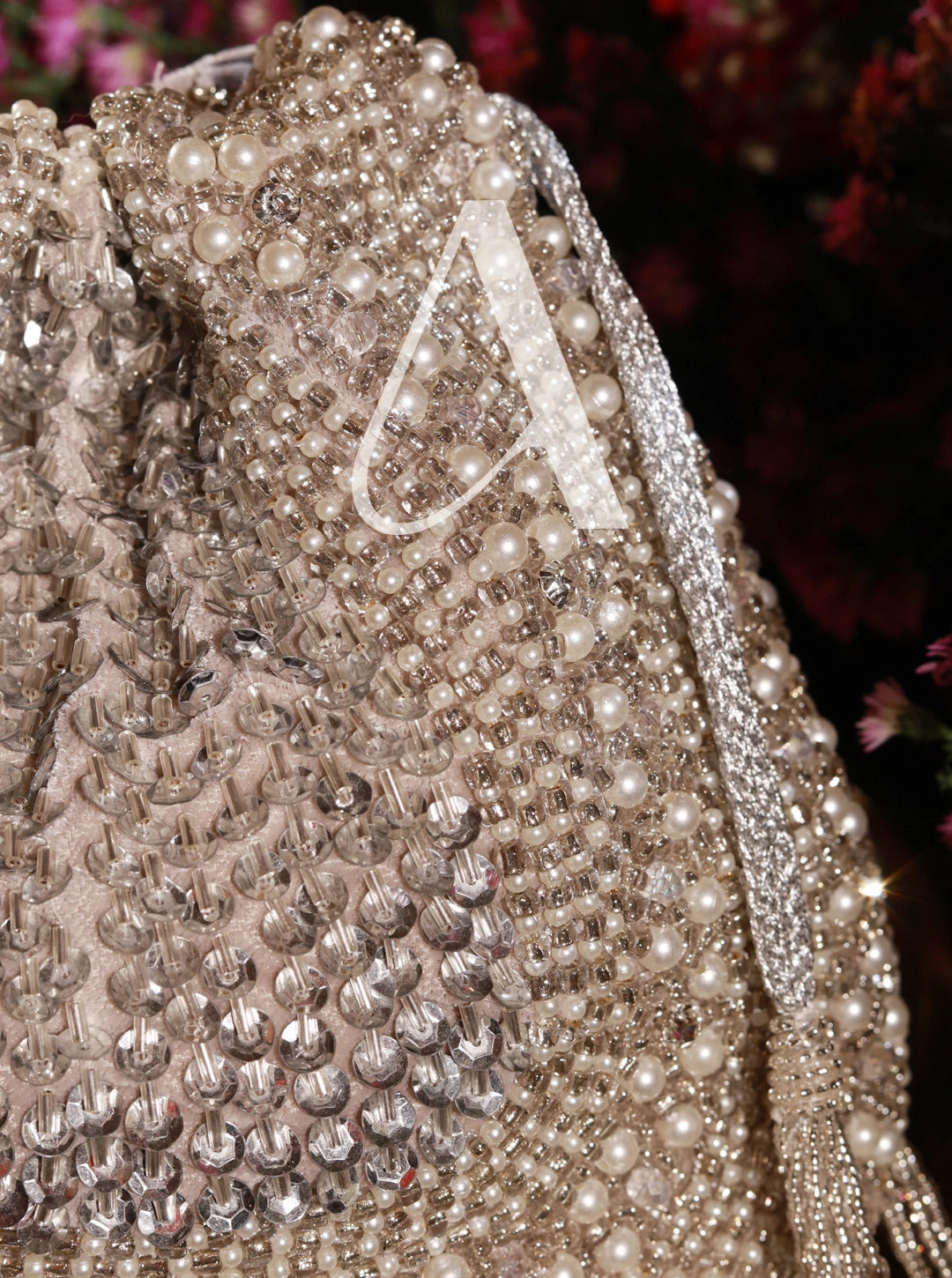 Close-up of a beaded handbag with a decorative letter 'A' on a dark background
