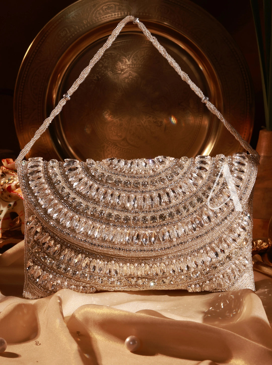 Silver beaded handbag on a reflective surface