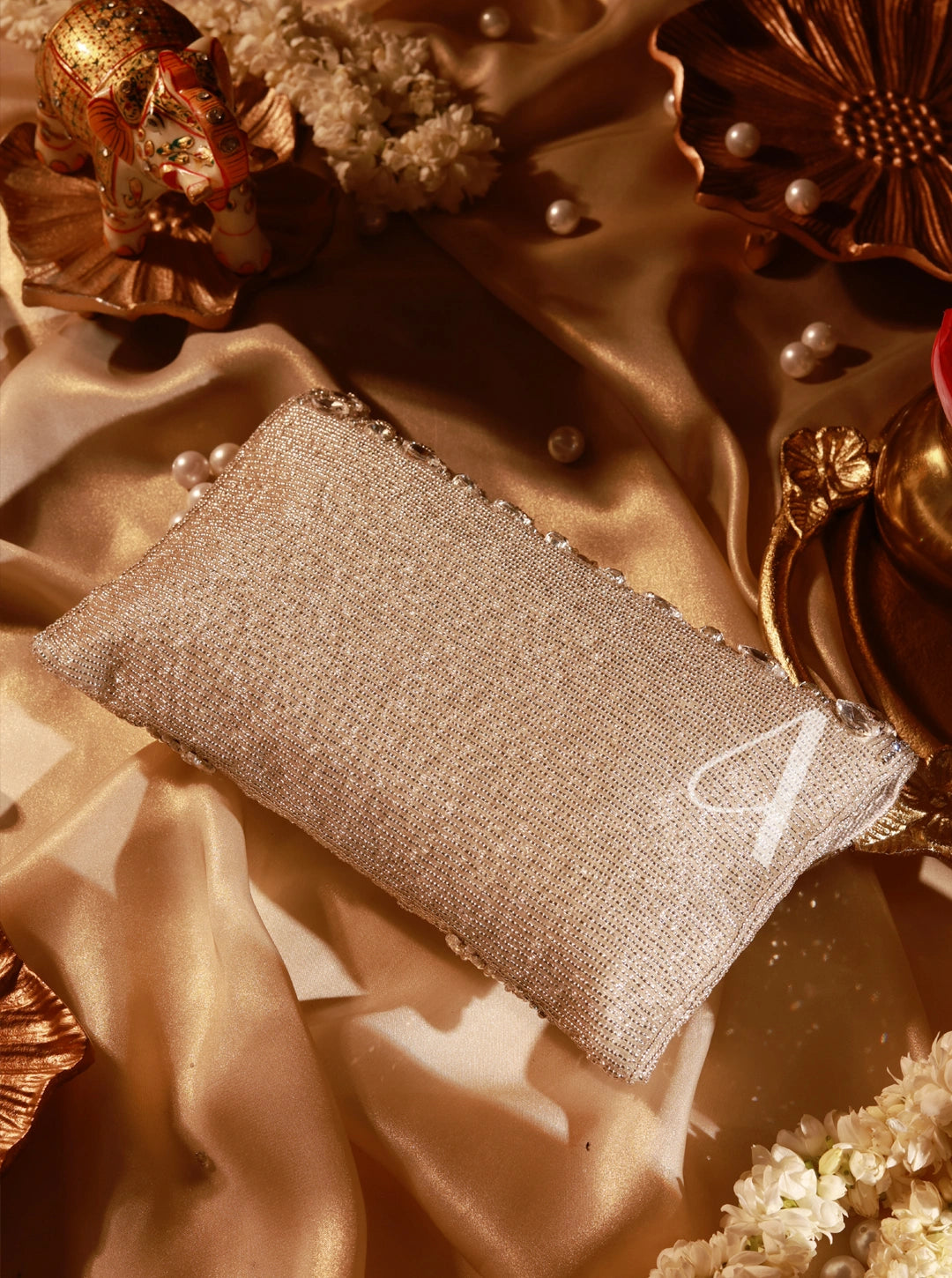 Sparkly clutch bag on a textured fabric background with decorative elements