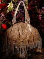 Beaded handbag with fringe detail in front of a floral background