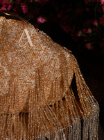 Close-up of a beaded fabric with a letter 'A' on a dark background
