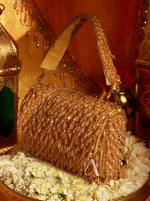 Gold glittery handbag on a decorative surface with lanterns in the background