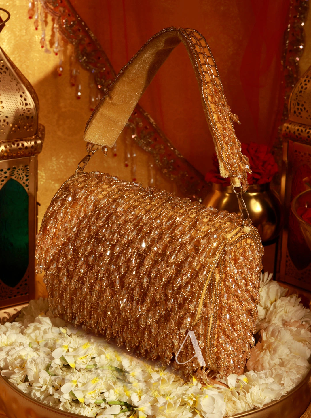 Gold glittery handbag on a decorative surface with lanterns in the background