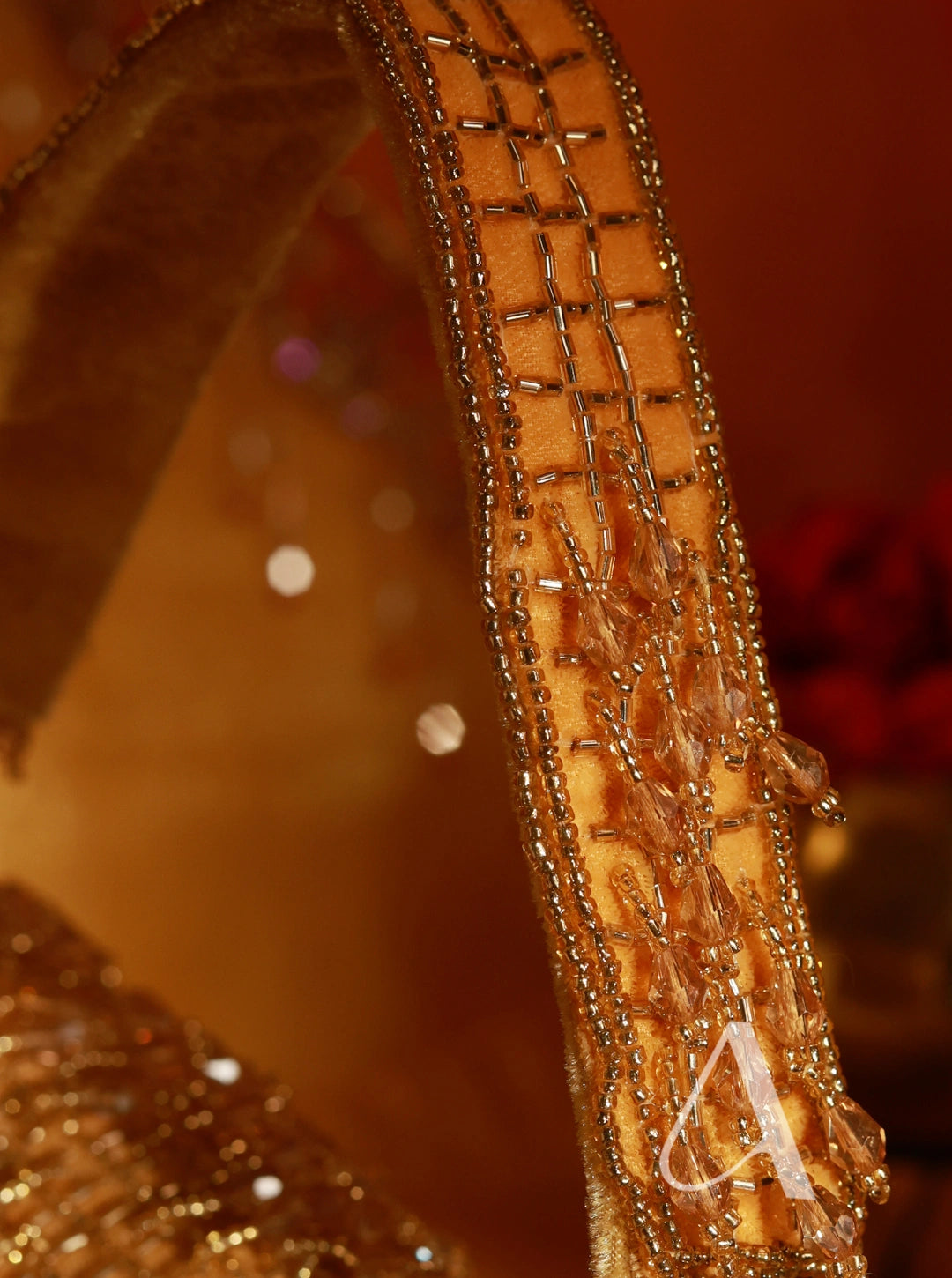 Close-up of a decorative gold headband with intricate patterns on a blurred background.