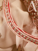 Close-up of a decorative necklace with red and silver beads on a person's neck.