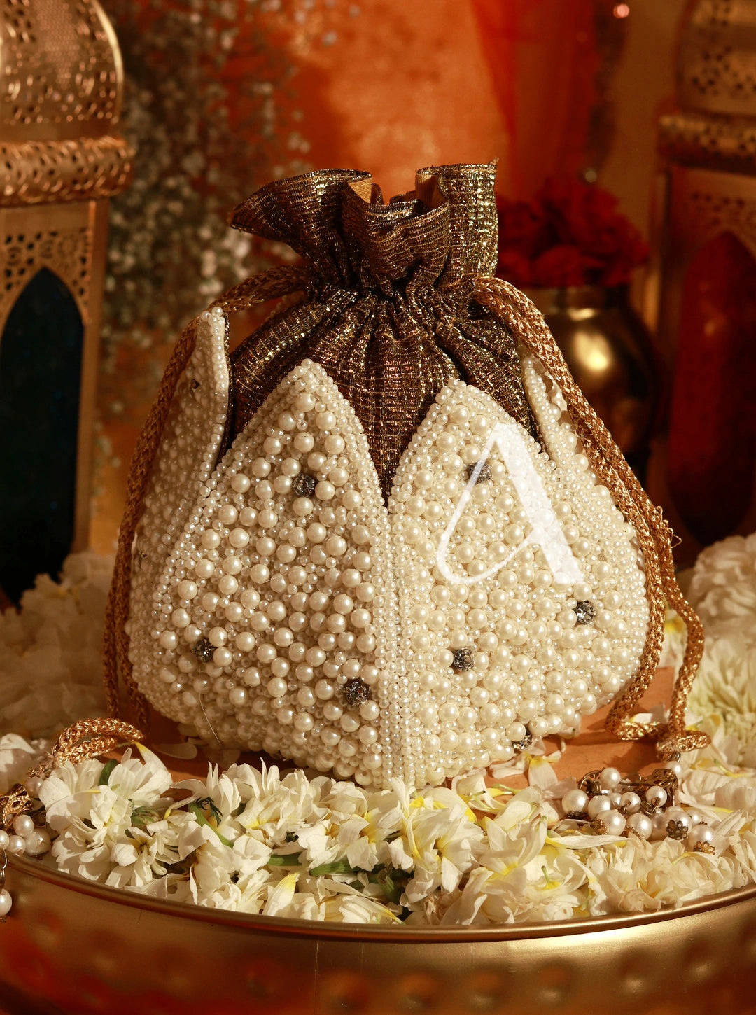 Decorative bag with pearls and a letter 'A' on a floral background