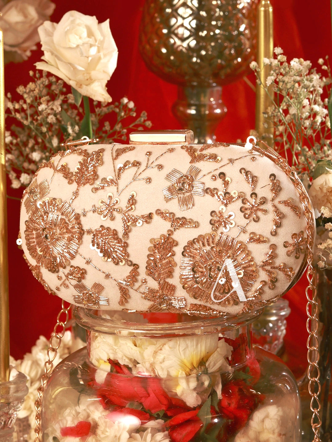 Decorative clutch bag with floral patterns on a stand with flowers and a red background