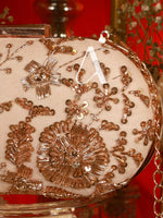 Decorative clutch with floral patterns and gold accents on a red background