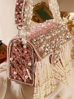 Pink handbag with pearls and decorative elements on a light background