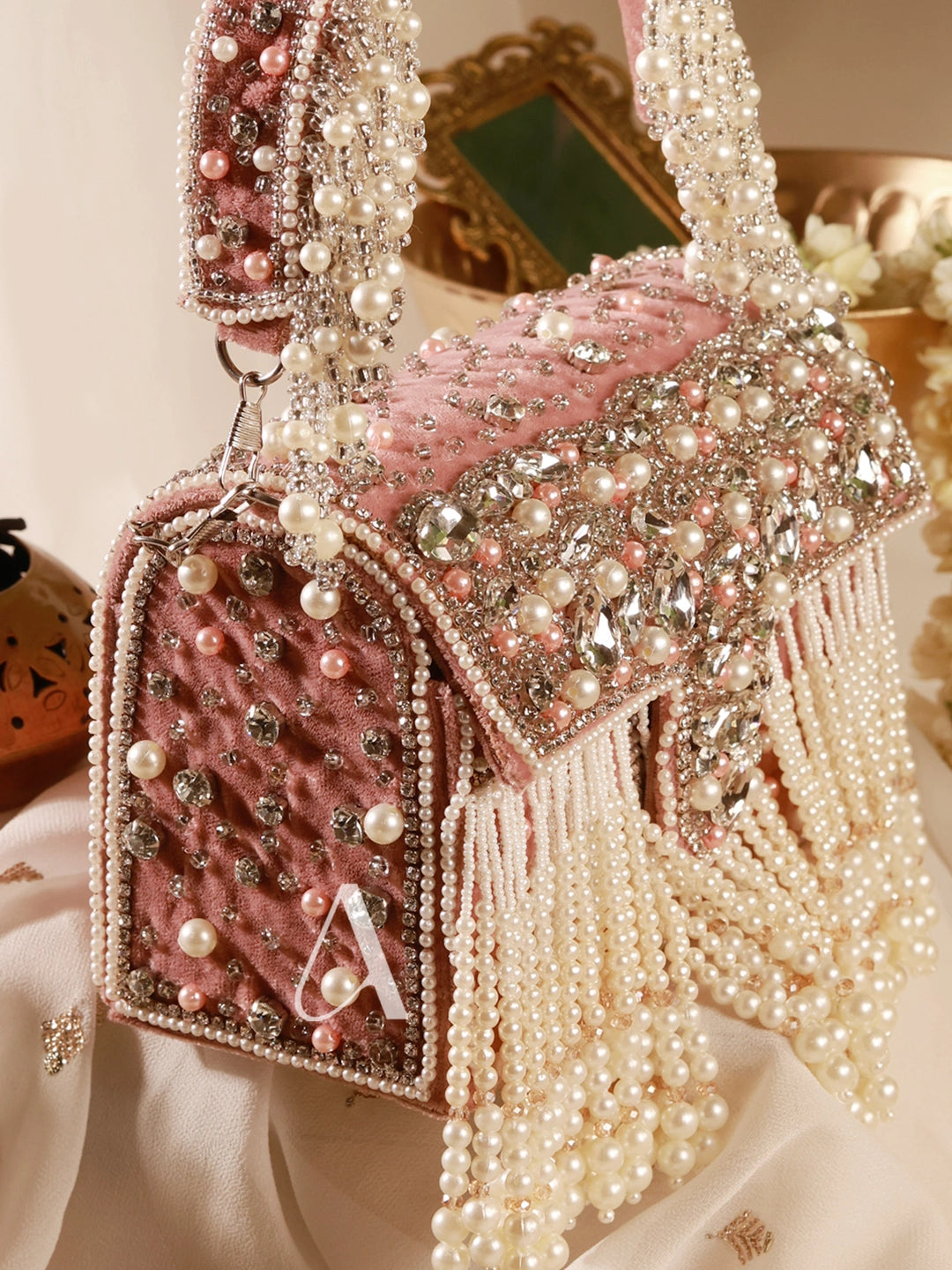 Pink handbag with pearls and decorative elements on a light background