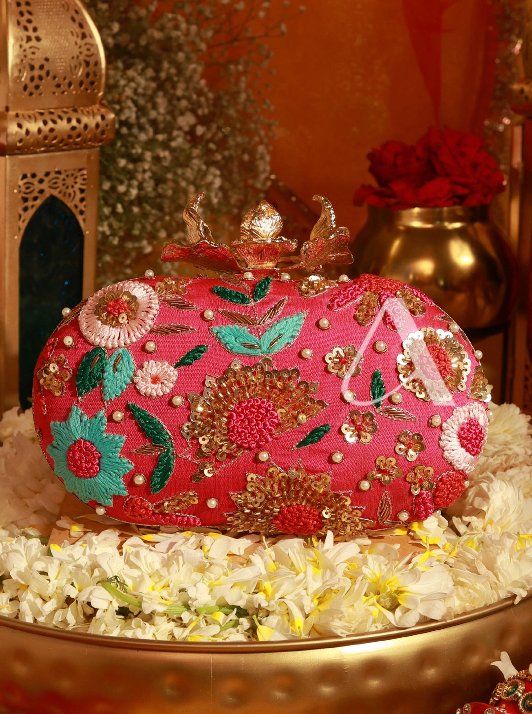 Decorative pink handbag with floral patterns on a decorative surface