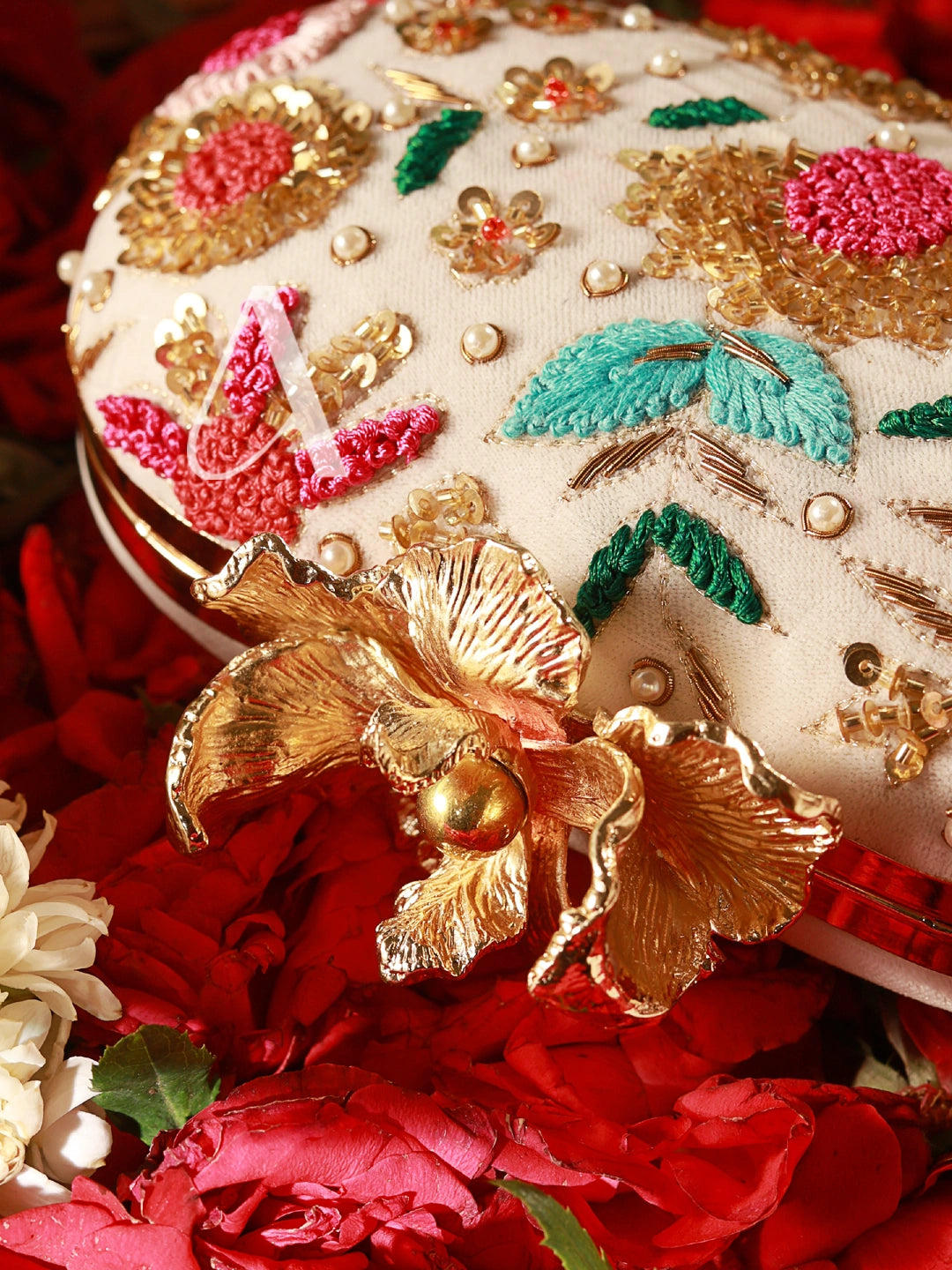 Decorative box with floral patterns and gold accents on a red floral background