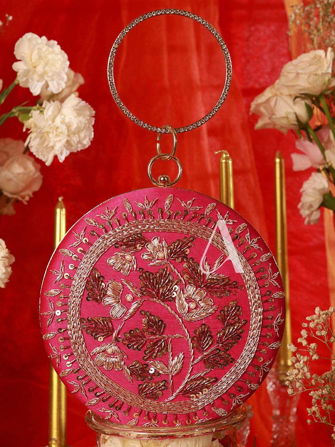 Decorative pink round ornament with floral patterns on a red background with flowers.