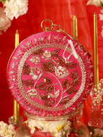 Decorative pink and gold round object with floral patterns on a red background