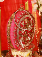 Decorative round object with gold embroidery on a red background