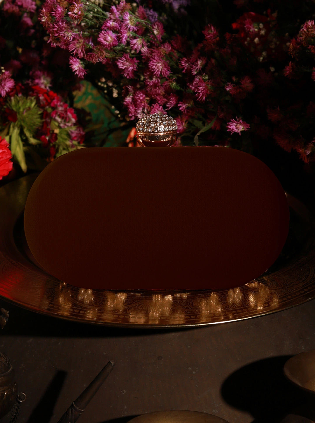Chocolate cake on a silver platter with flowers in the background