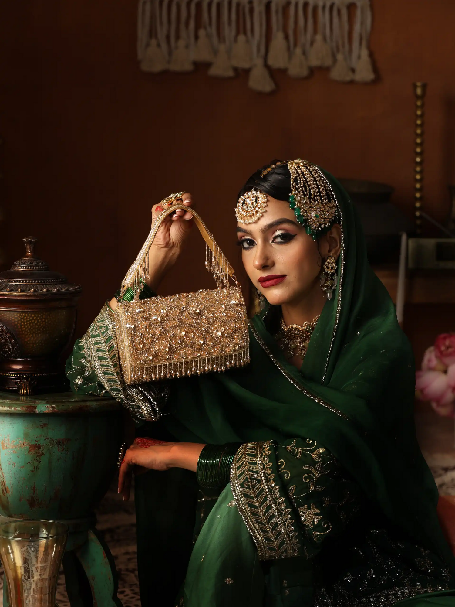Woman in traditional attire holding a decorative handbag in an indoor setting.