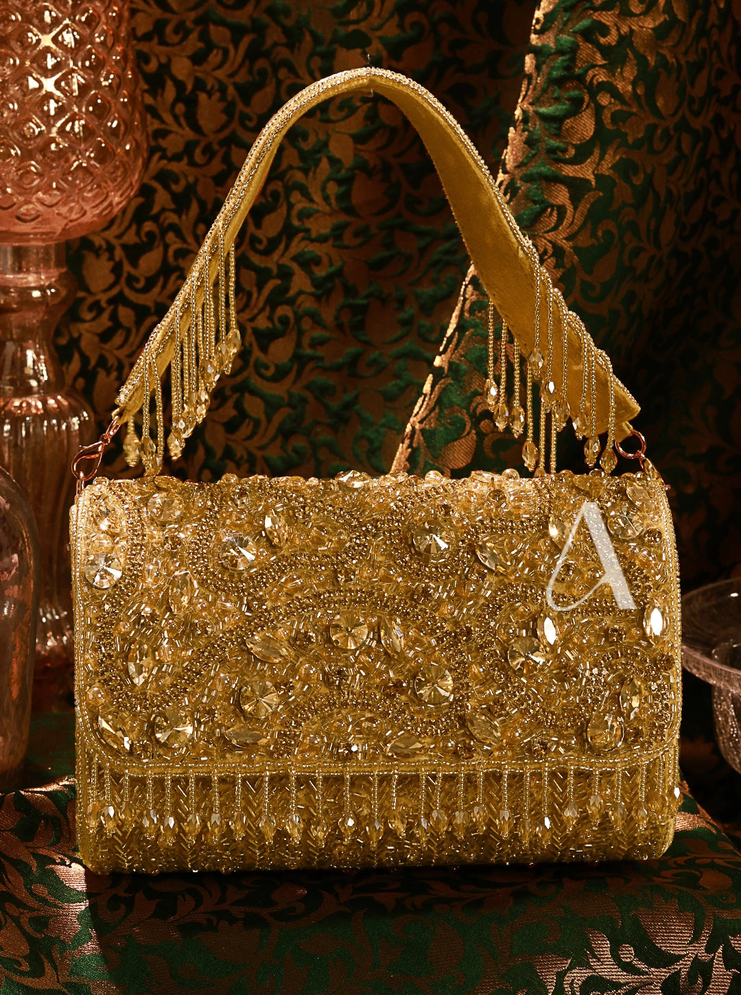 Gold handbag with intricate designs and embellishments on a patterned background