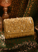 Gold beaded clutch bag on a decorative surface with a patterned background