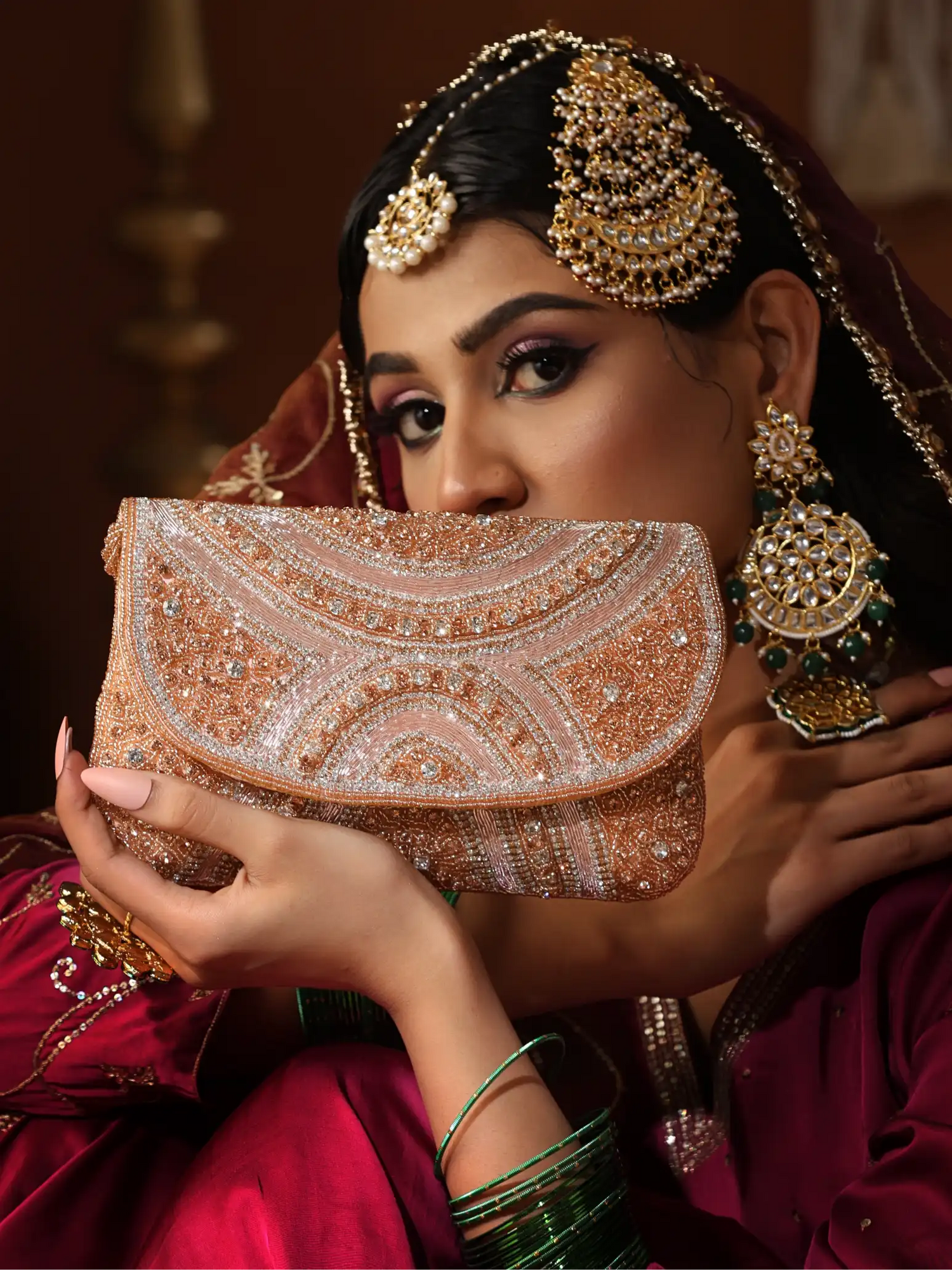 Woman in traditional attire holding a intricately designed clutch bag.