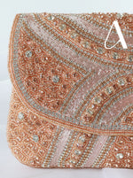 Rose gold clutch with intricate beading and embroidery on a white background