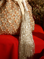 Decorative mesh bag with tassel on a red surface