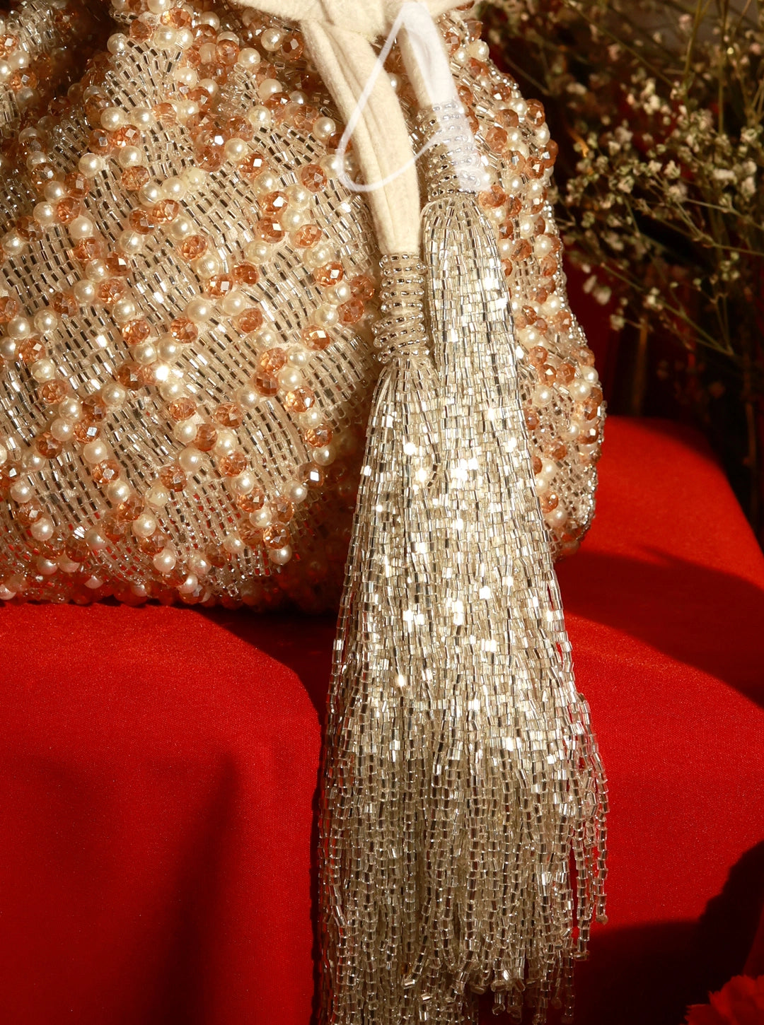 Decorative mesh bag with tassel on a red surface