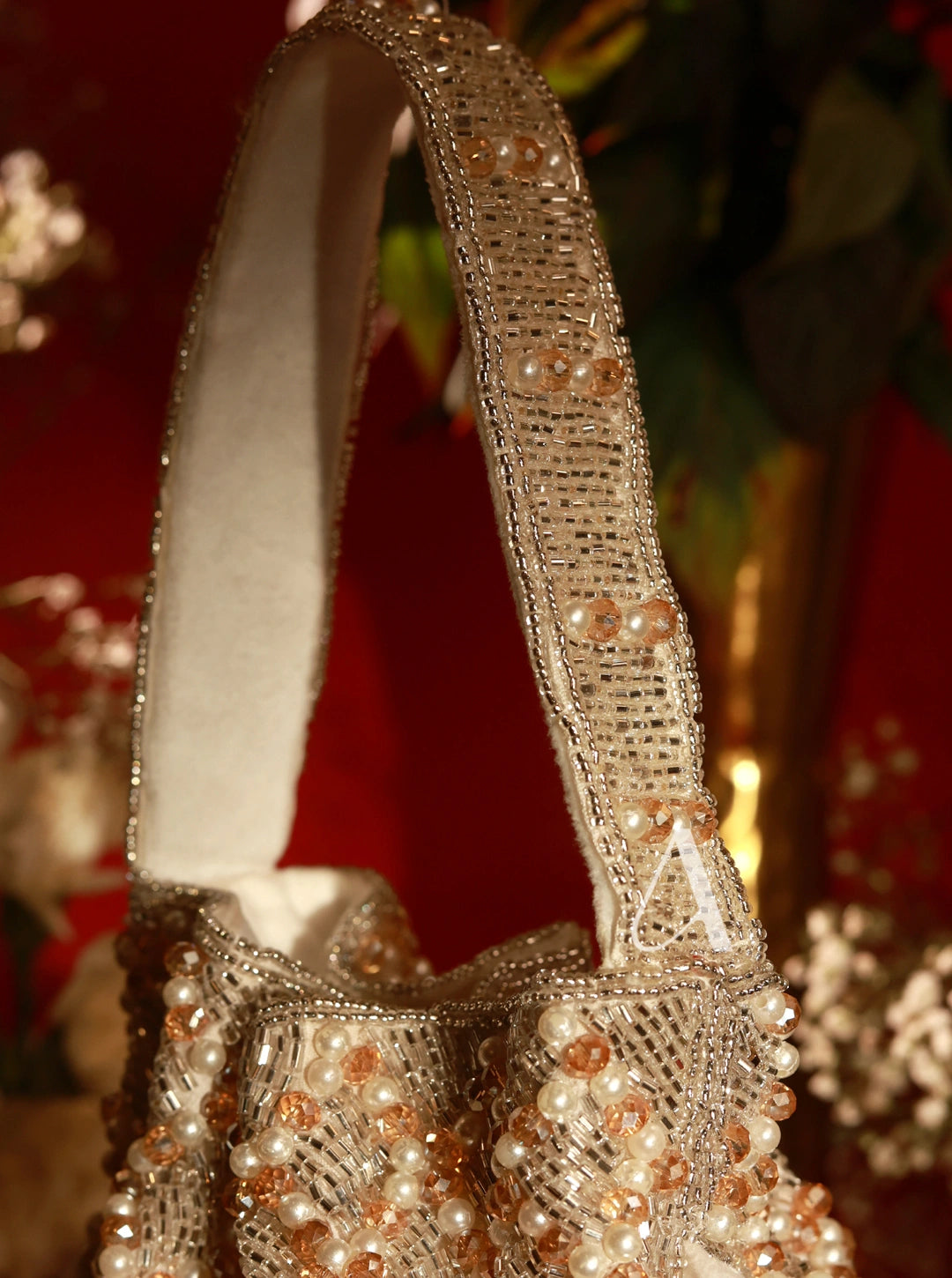 Decorative handbag with pearl and crystal embellishments on a blurred background